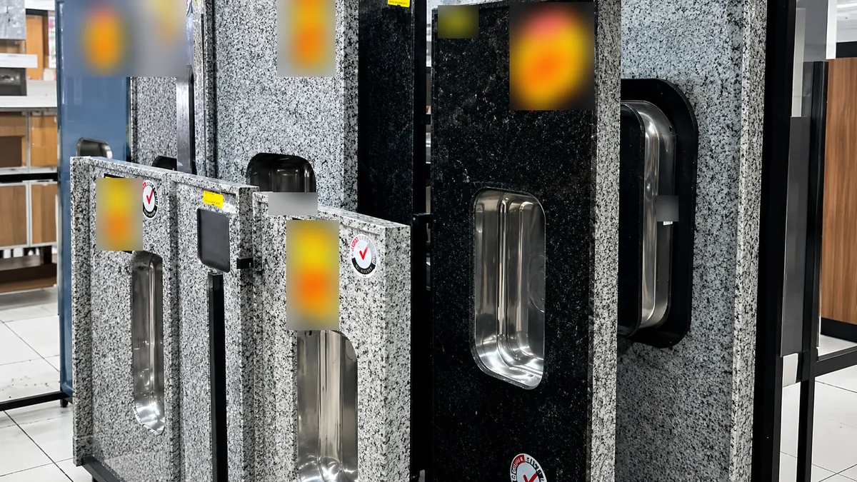 Pias e lavatórios de granilite com cuba de inox expostos no setor de louças e metais da loja